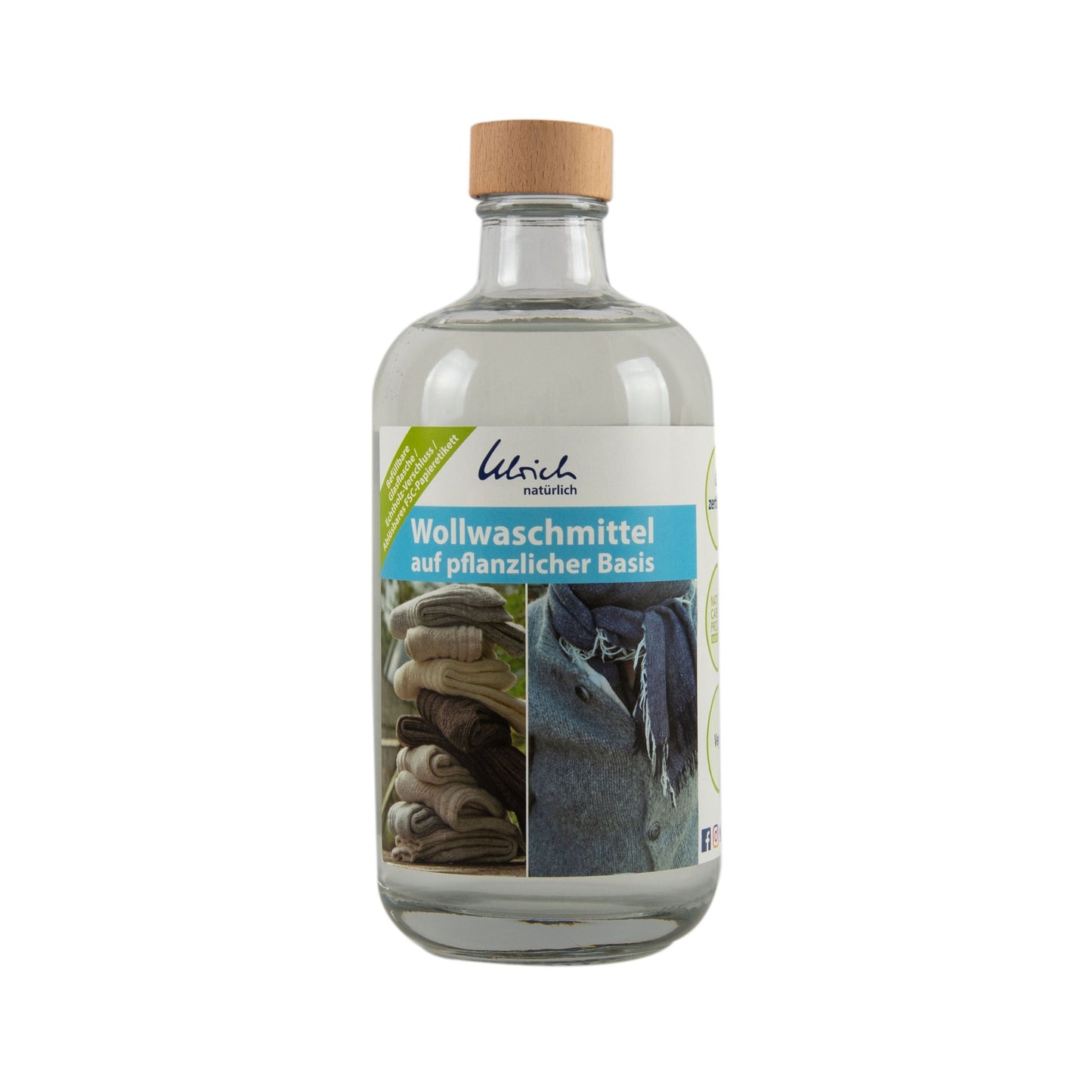 Dr. Ulrich ULRICH Wollwaschmittel 500ml Glasflasche ist eine klare Flasche mit einem Holzdeckel und einem Etikett, das gefaltete Wolle, ein Schaf und "Wollwaschmittel auf pflanzlicher Basis" zeigt. Geeignet für Wollwindeln und empfindliche Wollartikel.