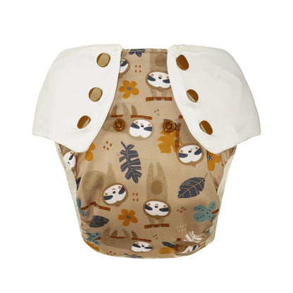 Der Lumina Pull-me-Up All in One Windel One-Size hat weiße Druckknöpfe auf beige, einen verspielten Faultier- und Blätterdruck in braun, blau und gelb und ist aus GOTS-zertifizierter BioBaumwolle für extra Komfort.