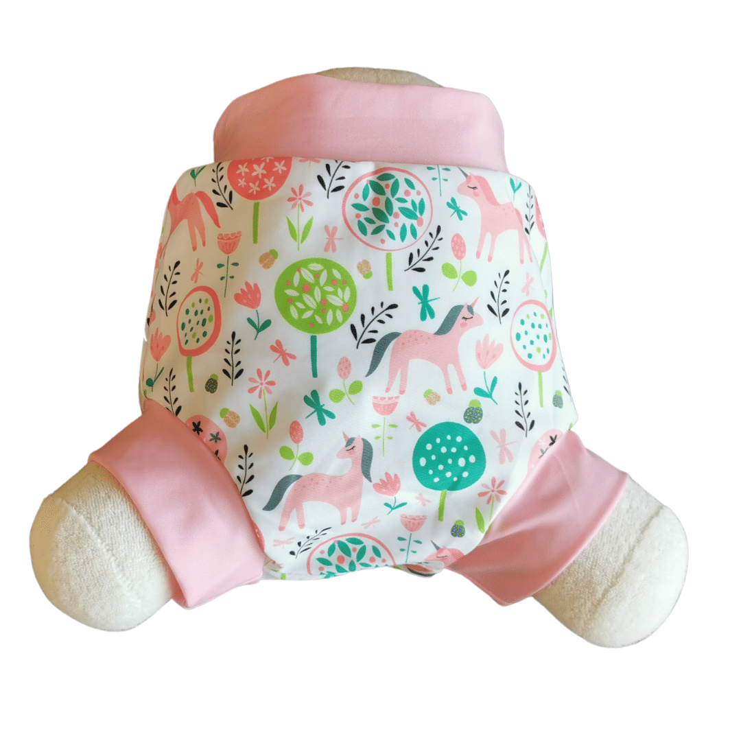 Ein Stofftier trägt die Lumina Schwimmwindel Pull Up, eine farbenfrohe Schwimmwindel mit rosa und grünen Baum-, Blumen- und Pferdemustern sowie rosa Zierleisten am Bund und an den Beinöffnungen für einen bequemen Sitz.