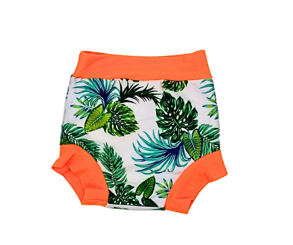 Der Lumina Schwimmwindel Pull Up hat eine hohe Taille mit tropischem Blattdruck auf weißem Grund und leuchtend orangefarbenen Bund- und Beinabschlüssen für Komfort und Stil.