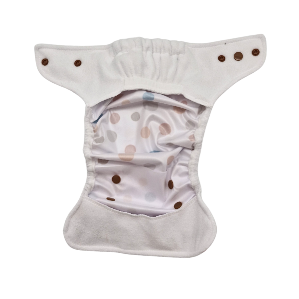 Die offene Überhose für Neugeborene von Lumina ist eine wiederverwendbare Stoffwindel mit weißer Außenseite, braunen Druckknöpfen und einem weichen Minky-Fleece-Futter in Pastell und braunen Tupfen, das flach hingelegt wird, um das Innere zu zeigen.