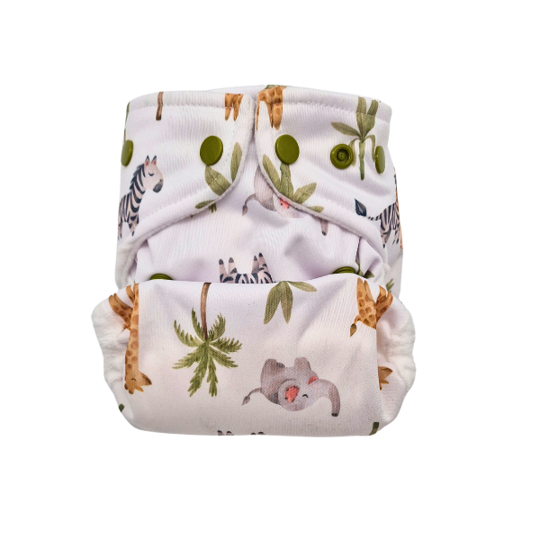Die Lumina Überhose für Neugeborene ist eine wiederverwendbare Stoffwindel aus weichem Minky Fleece mit grünen Druckknöpfen, auf denen Dschungeltiere wie Zebras, Faultiere und Giraffen mit Blättern auf weißem Hintergrund abgebildet sind.