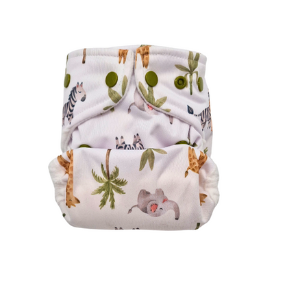 Die Lumina Überhose für Neugeborene ist eine wiederverwendbare Stoffwindel aus weichem Minky Fleece mit grünen Druckknöpfen, auf denen Dschungeltiere wie Zebras, Faultiere und Giraffen mit Blättern auf weißem Hintergrund abgebildet sind.