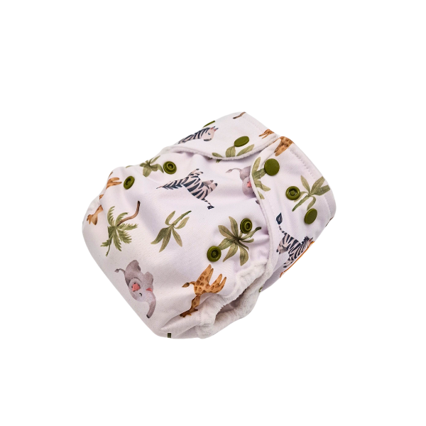 Die Lumina Überhose für Neugeborene ist eine wiederverwendbare Stoffwindel aus weichem Minky Fleece mit grünen Druckknöpfen und einem Safaritier-Print - Elefanten, Giraffen und Zebras - auf weißem Untergrund. Ideal für Neugeborene.